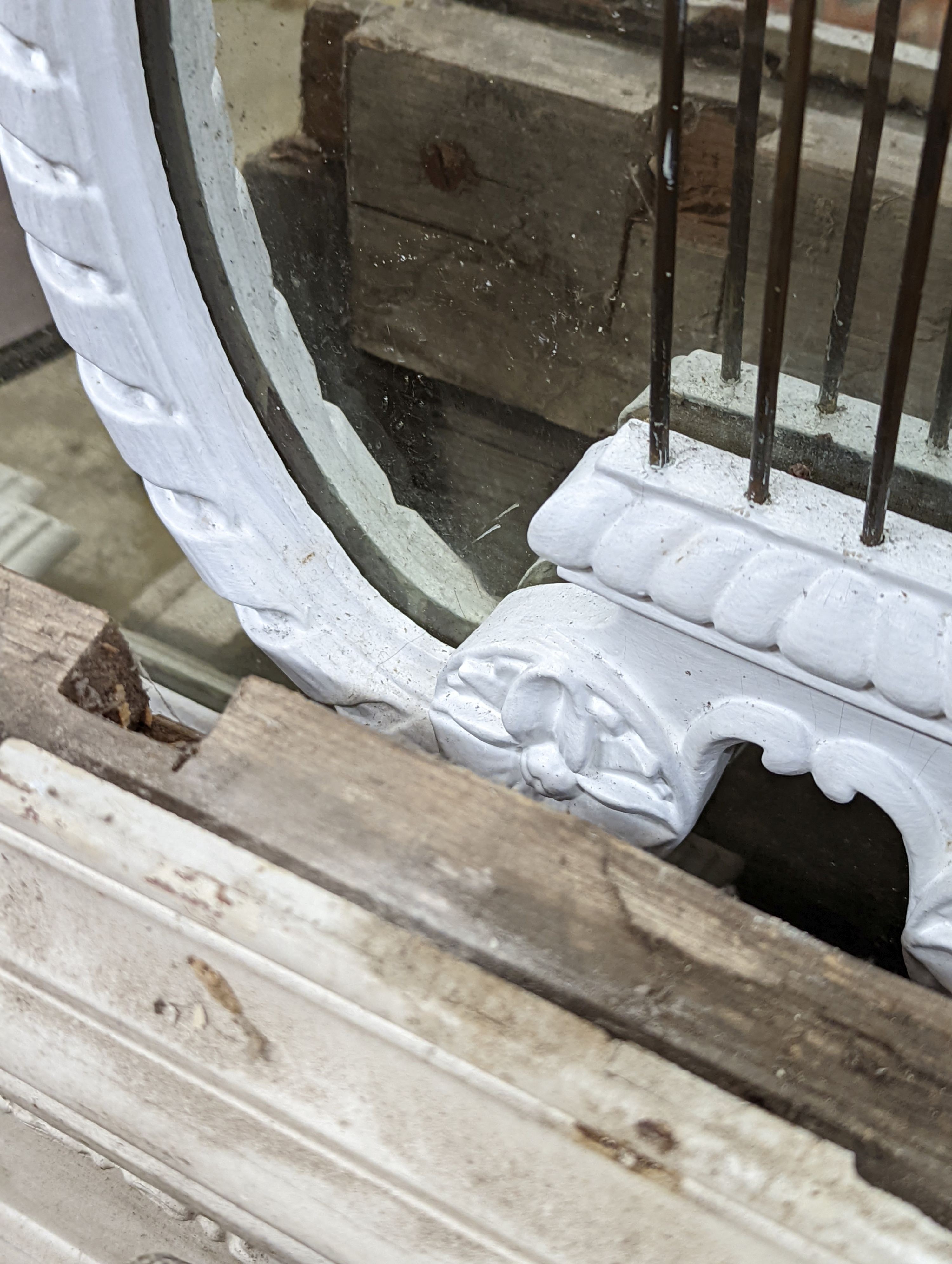 An Edwardian carved wood and gesso overmantel with cherub surmount, later painted white, width 188cm, height 96cm and a two white painted door pediments in need of restoration